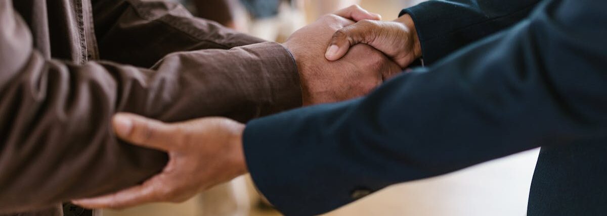 Close-up of two businesspeople shaking hands, symbolizing agreement and partnership.